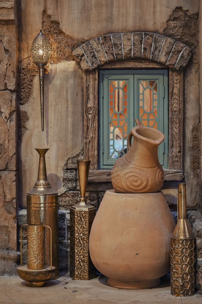 Beautifully crafted clay pots are positioned in front of a window