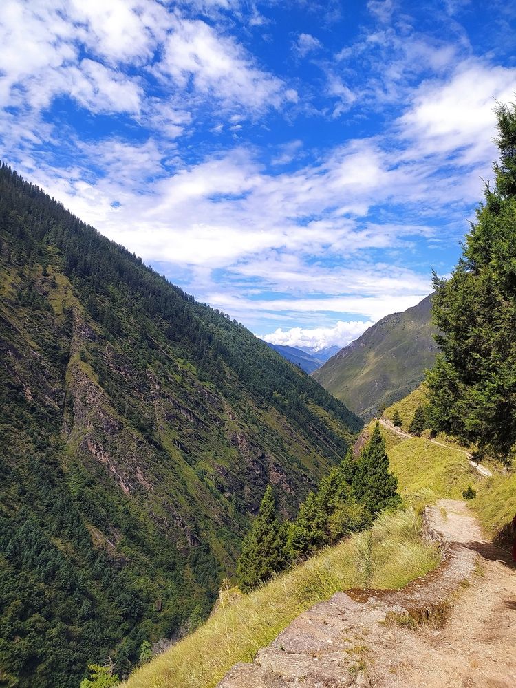 In midst of rugged mountain beneath a blue sky.
