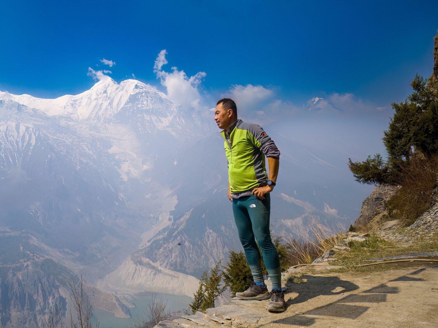 the person is trekking or hiking along a mountain trail.