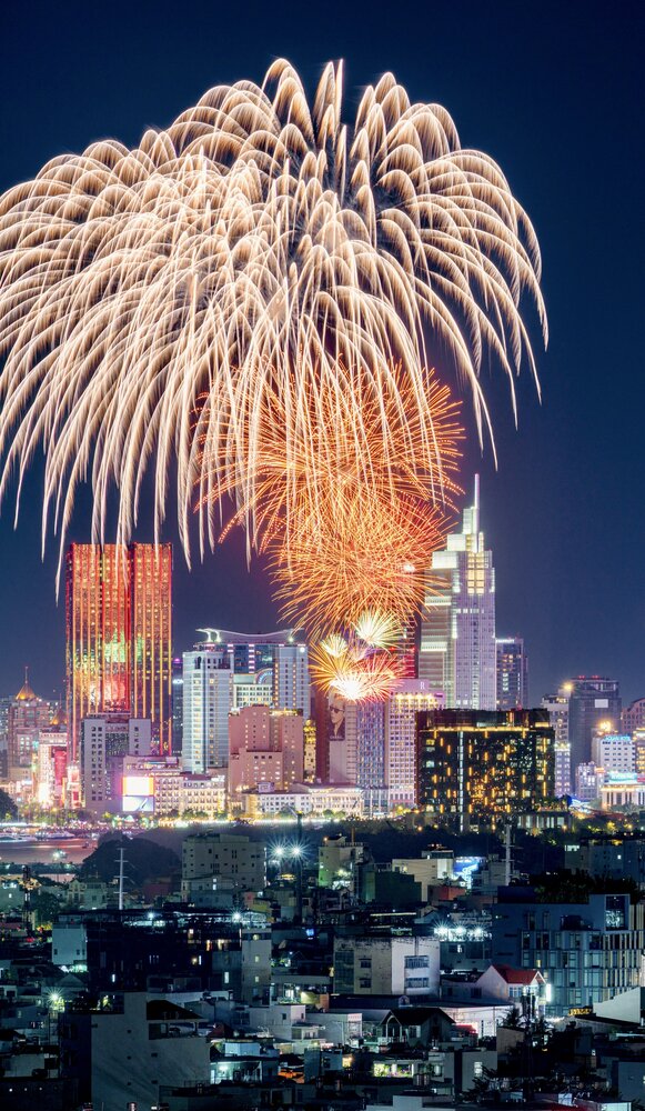 Orange Fireworks Reflecting on City Skyscraper at Night