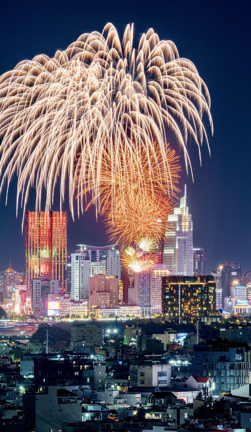 Orange Fireworks Reflecting on City Skyscraper at Night