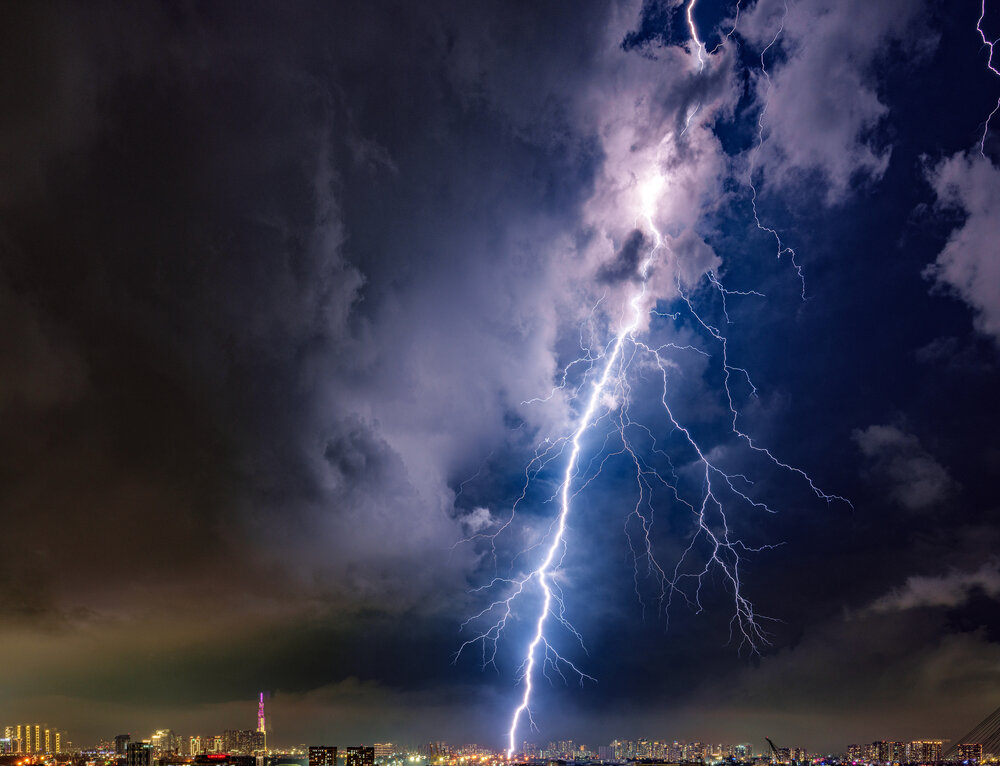 Dramatic Lightning Strike Over City Skyline at Night