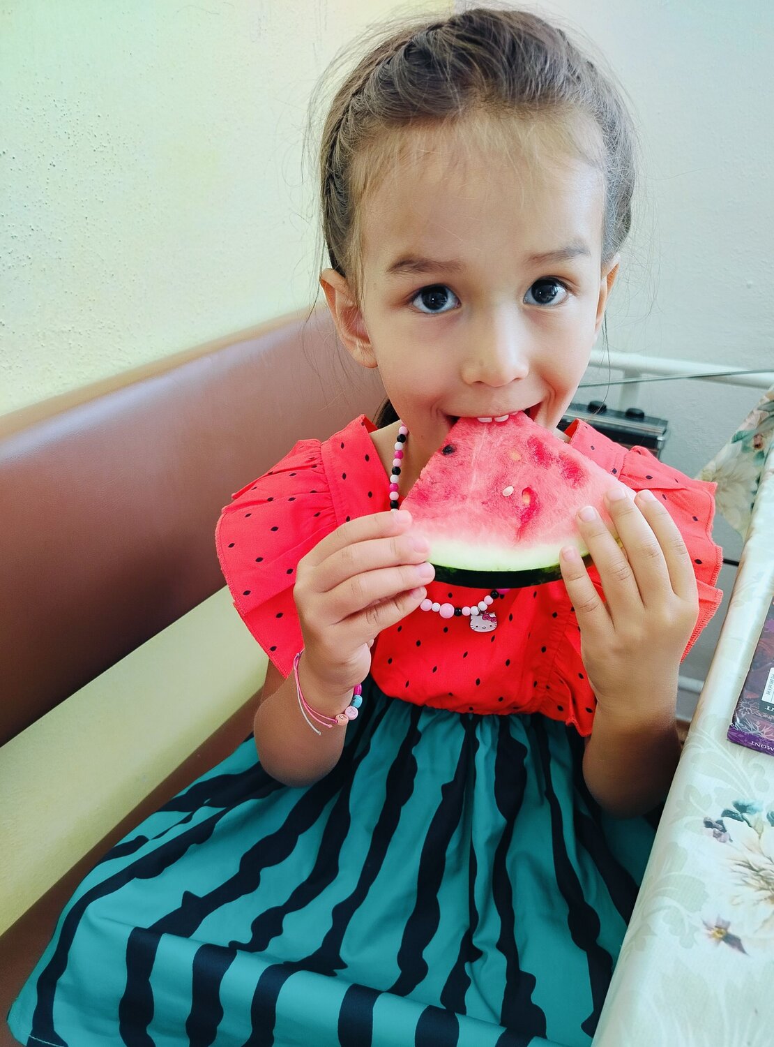 Little Girl In Watermelon Dress Eating Watermelon Slice