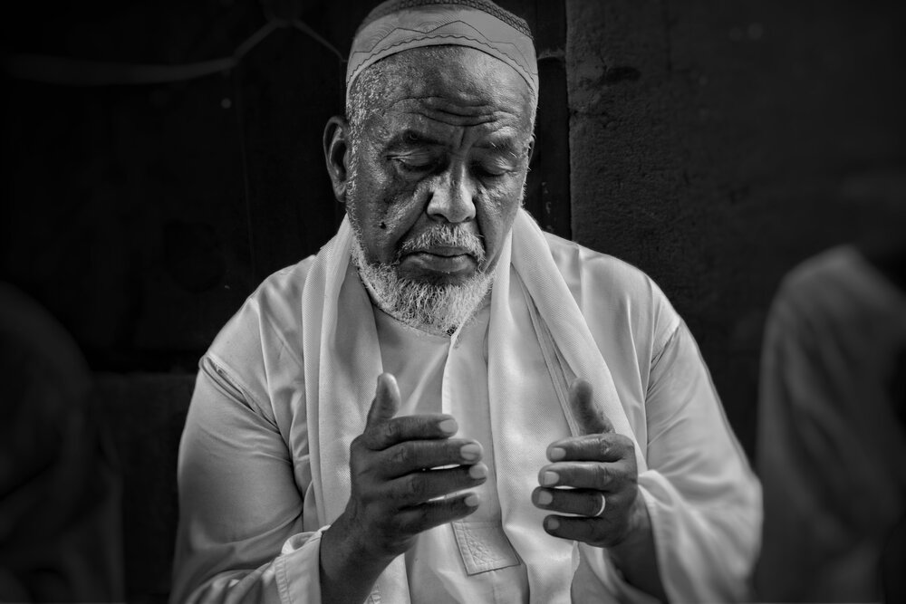 Black and White Portrait of Sudanese Man in Traditional Islamic Prayer