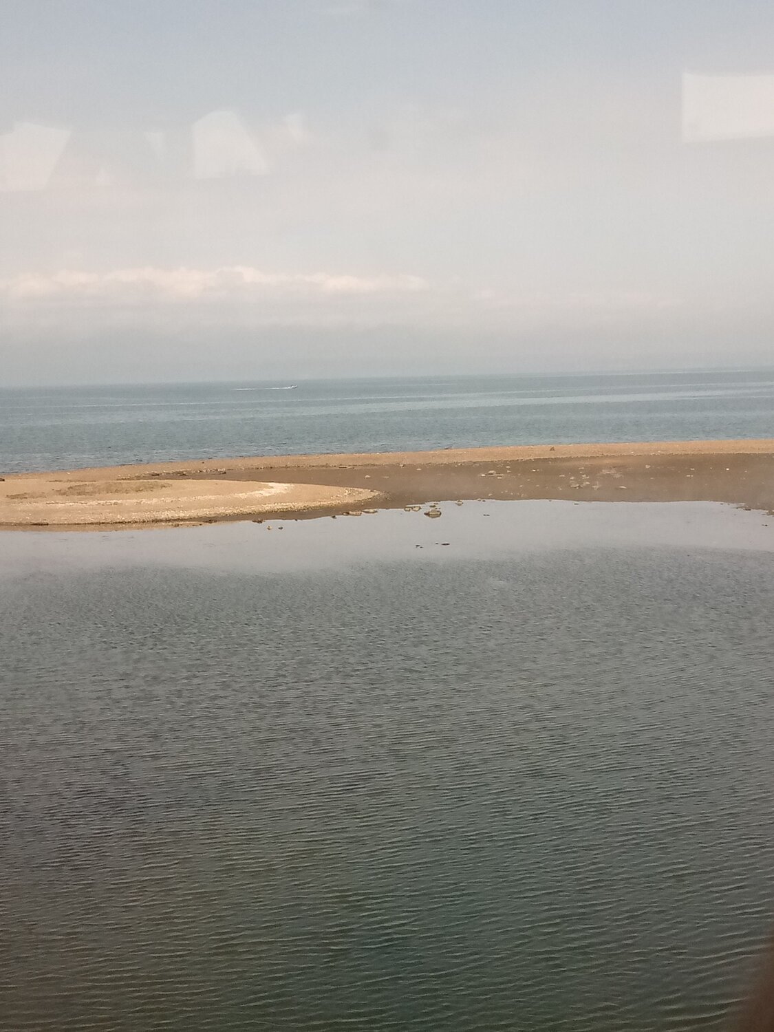 Полоска пляжа среди воды.
