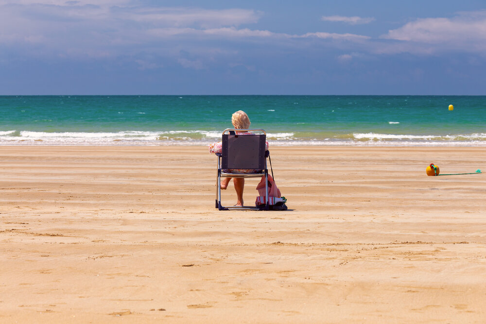 Woman Relaxing on Sandy Beach Facing the Atlantic Ocean in Cadiz, Spain
