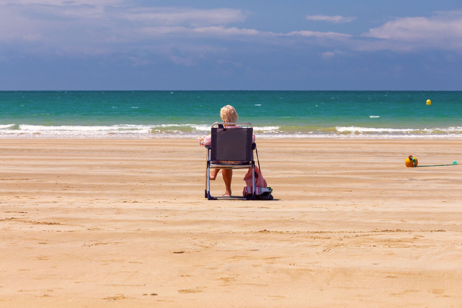 Woman Relaxing on Sandy Beach Facing the Atlantic Ocean in Cadiz, Spain