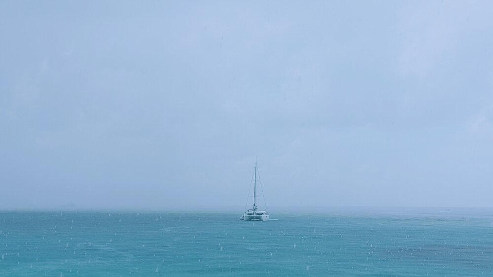 A lonely catamaran in the rain in the Caribbean Sea
