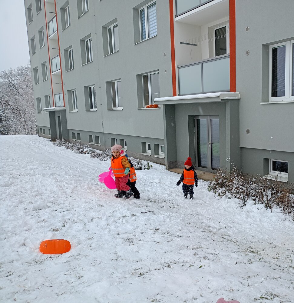 Children in Orange Safety Vests Playing in Snow Winter