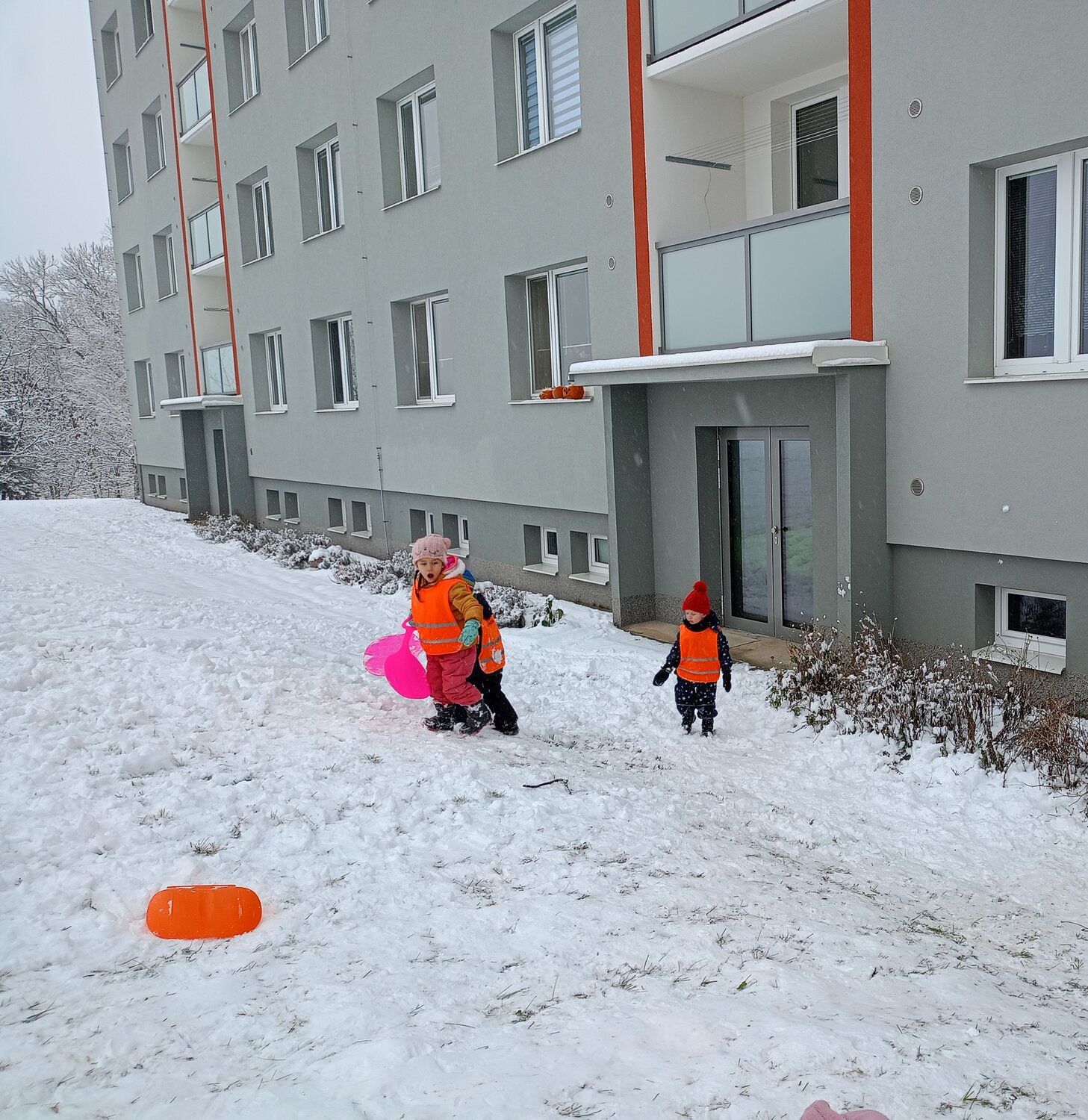 Children in Orange Safety Vests Playing in Snow Winter