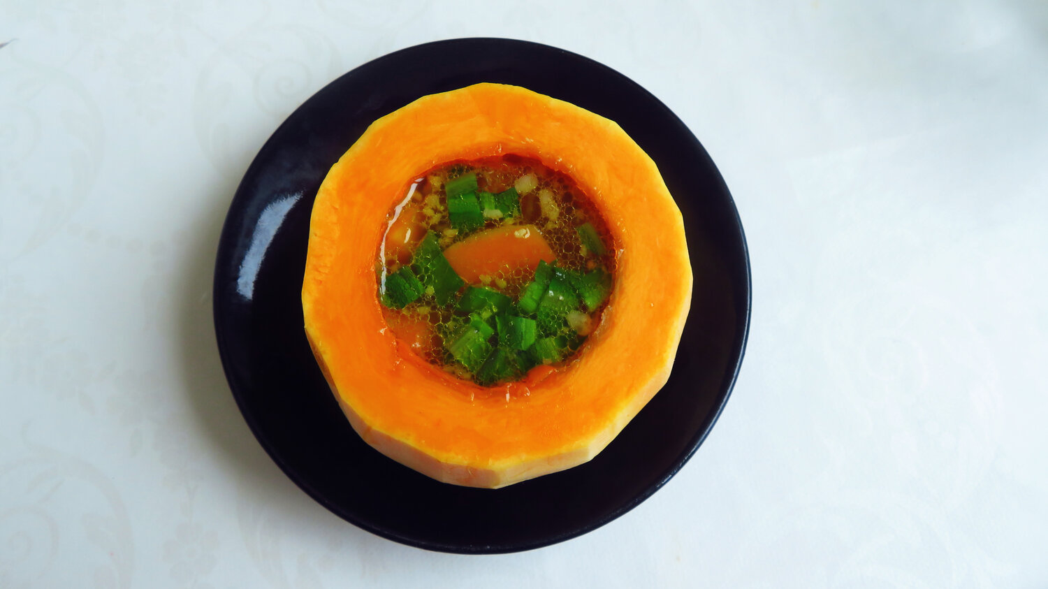 Orange Pumpkin Soup Served in Hollowed Pumpkin Bowl