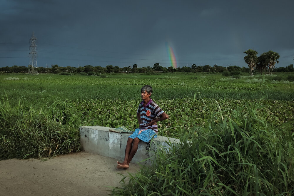 Rainbow behind rural man