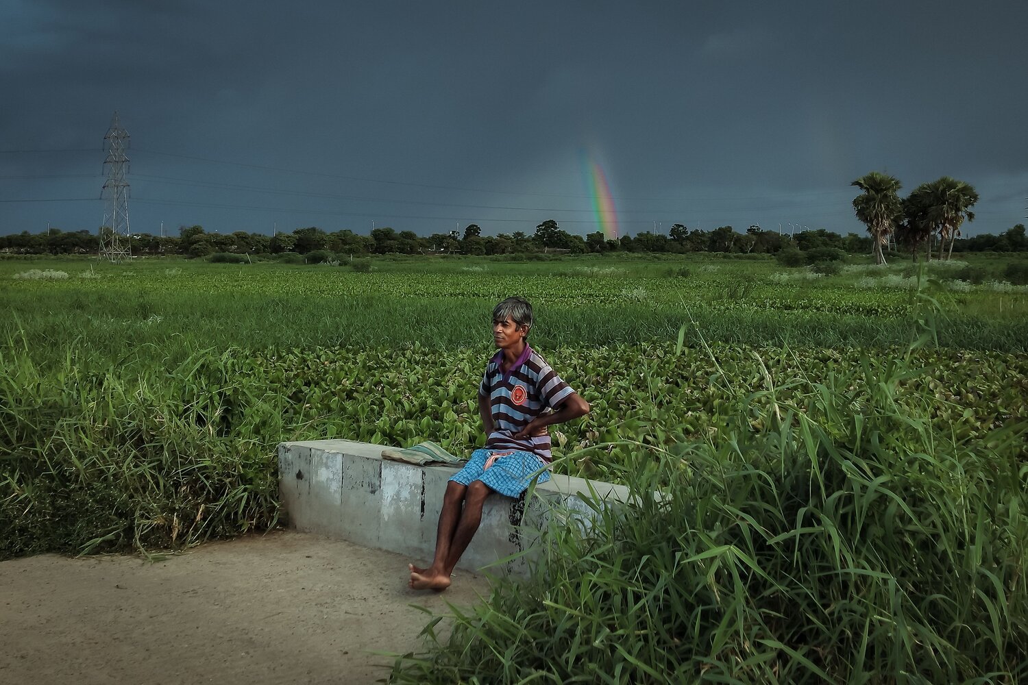 Rainbow behind rural man