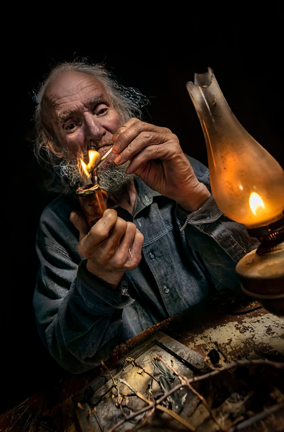 Old man lighting a pipe