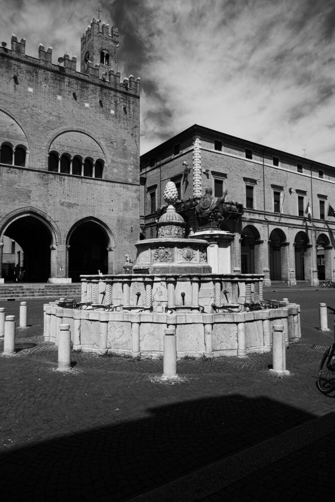 Fontana della Pigna a Rimini con nubi e storia