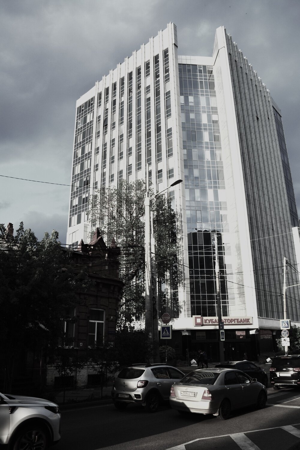 Одноэтажный дом старинной архитектуры на фоне современного здания. Одноэтажный дом старинной архитектуры на фоне современного здания.