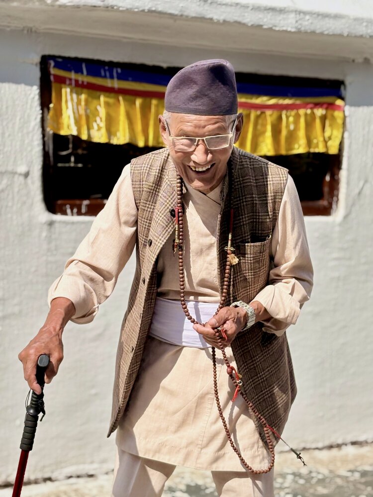 Spiritual joy - Elderly Tibetan Buddhist man laughing at a monastery in Nepal