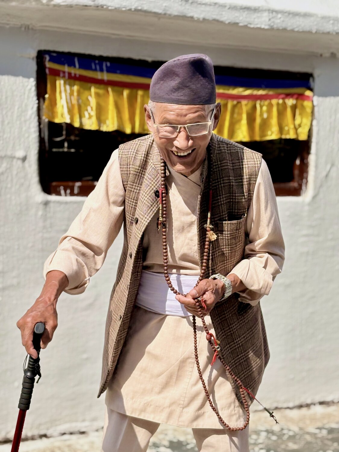 Spiritual joy - Elderly Tibetan Buddhist man laughing at a monastery in Nepal