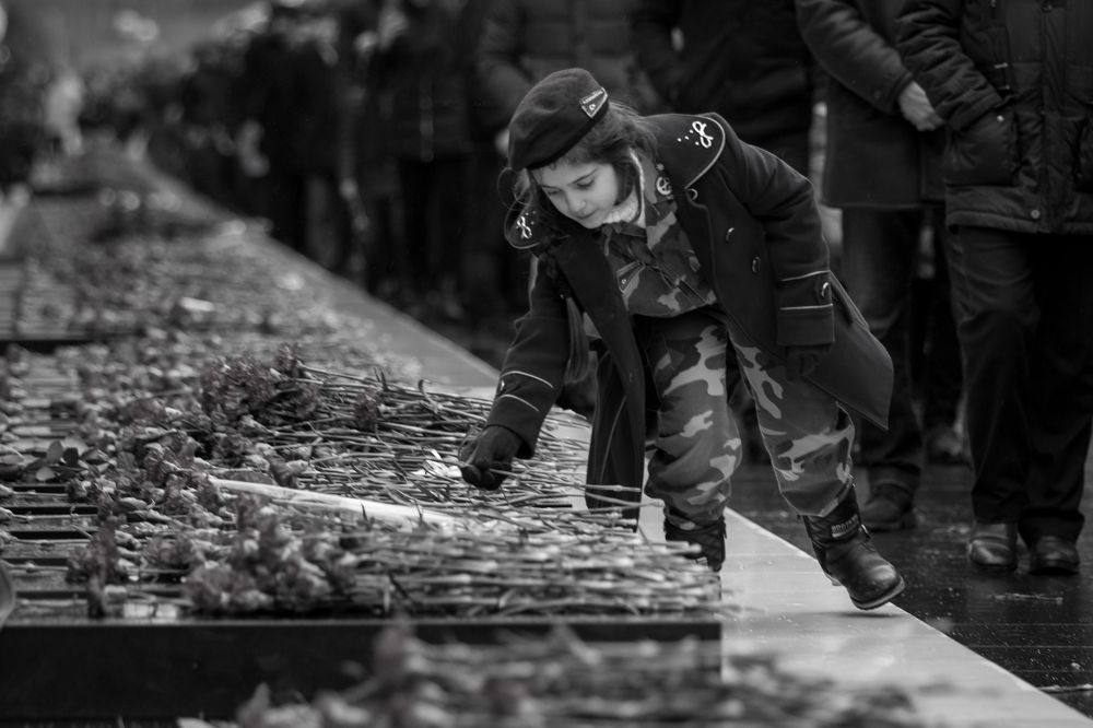 Девочка ставит цветы на могилы