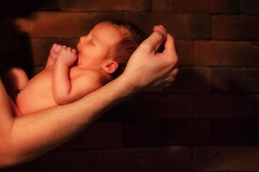 На руках отца.