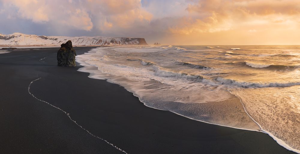 Вид на пляж Рейнисфьяра с полуострова Дирхоолей