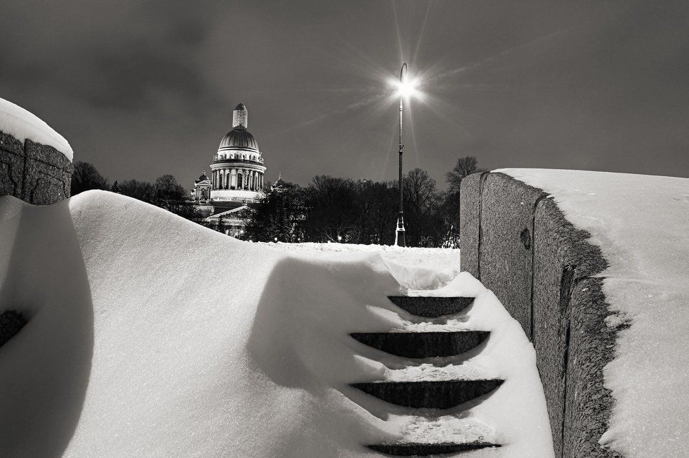 St. Petersburg View of St. Isaac's Cathedral on a winter night. Snow levels granite embankment_