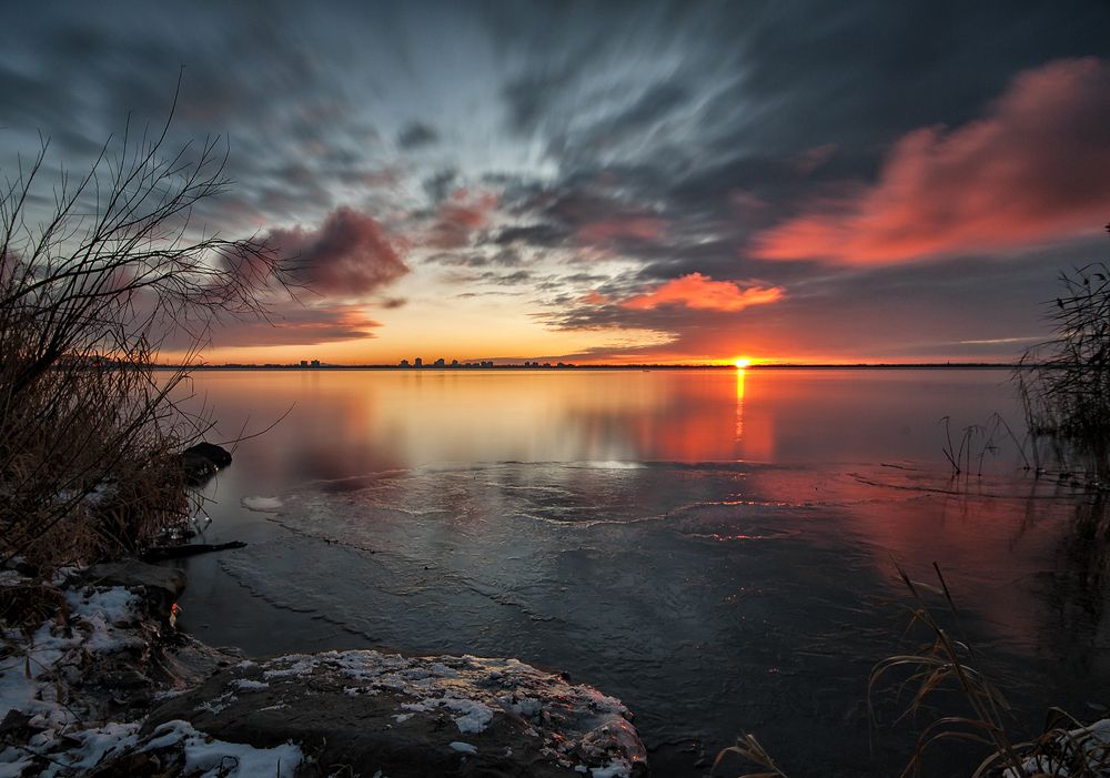sunrise at frozen lake shore.
