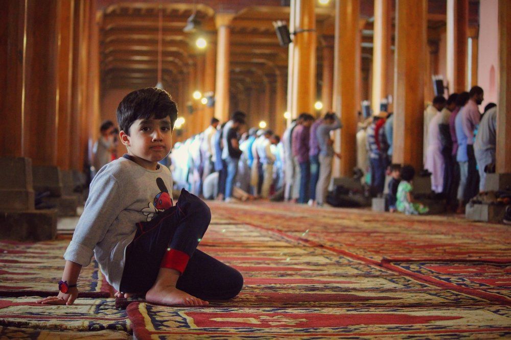 A kashmir kid poses for a photo in kashmir's famous jamia masjid during asar prayers in the holy month of Ramadan