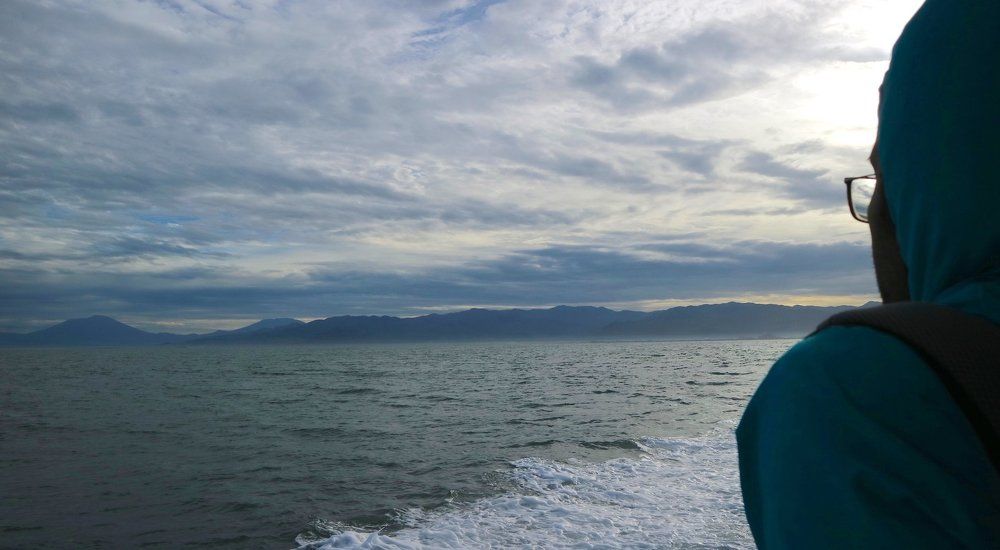 A Standing Passenger and Steady Mountains of Padang port