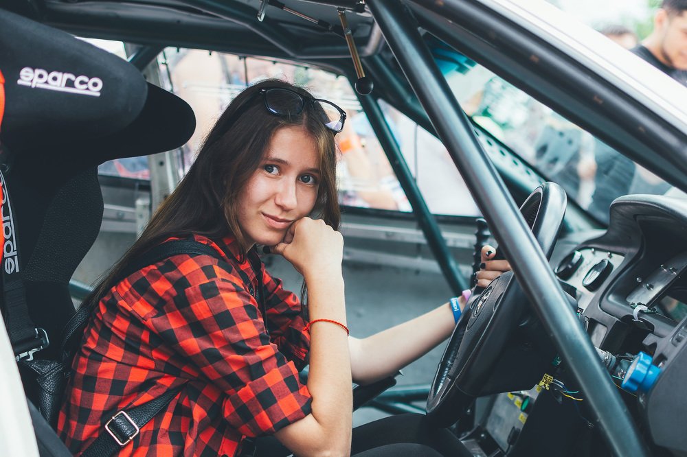 Девушка за рулем гоночного автомобиля.