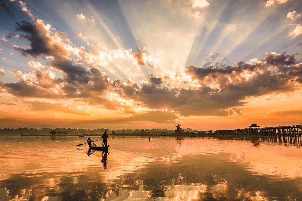 Fishermen under sunrise rays