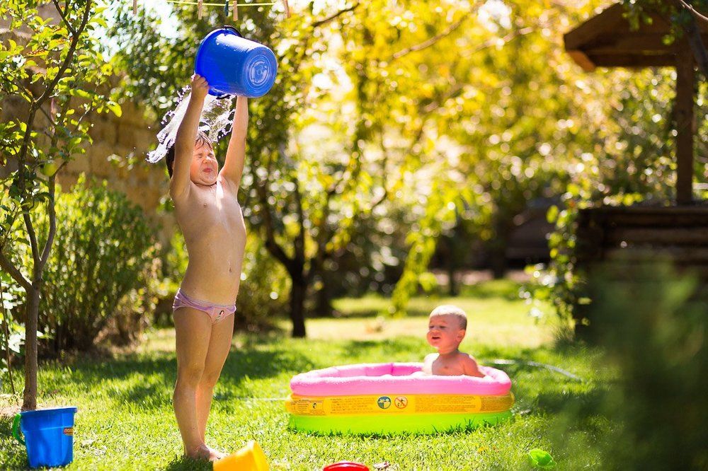 Sisters in a garden playing water games