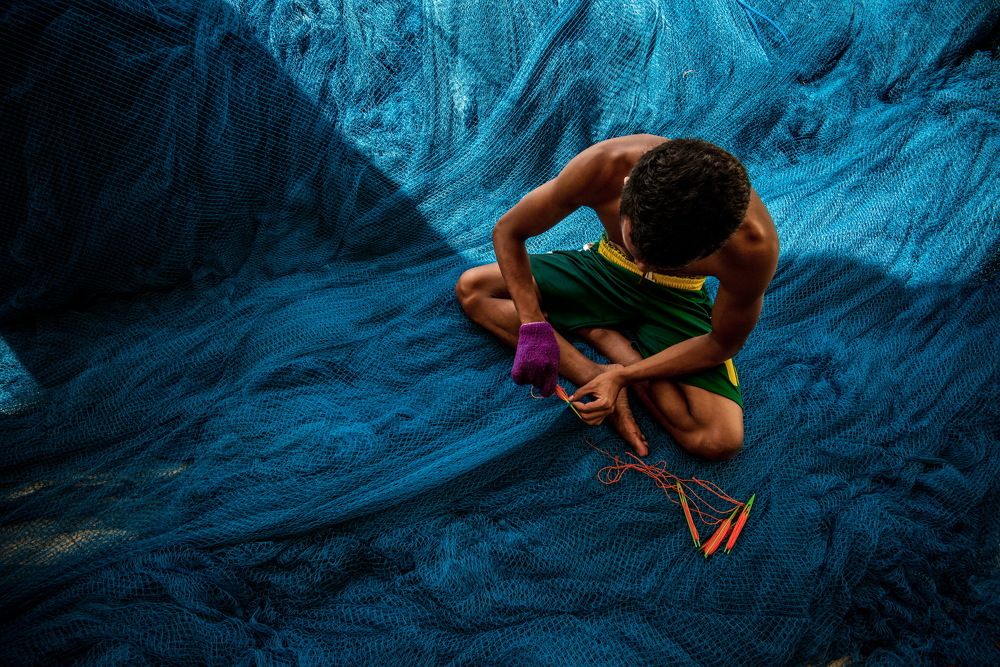 Fisherman And Sewing Fishing Nets