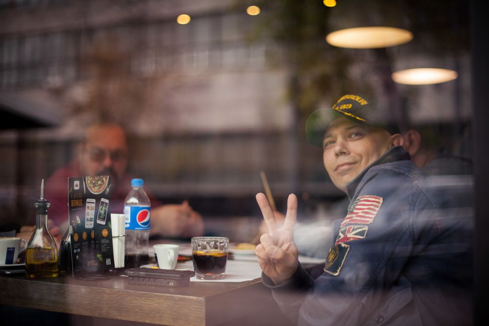 За стеклом.