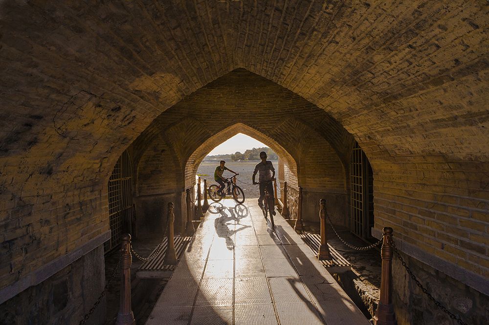Cyclists passing under the arch of old boys