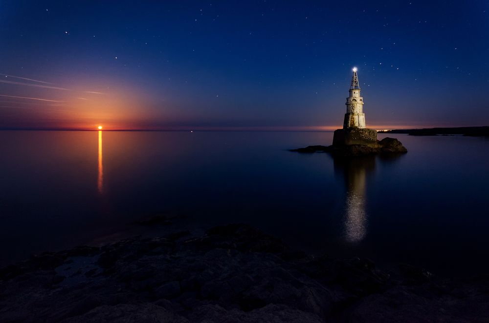 The rise of Full moon over the lighthouse