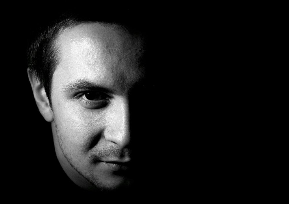 Из темноты.