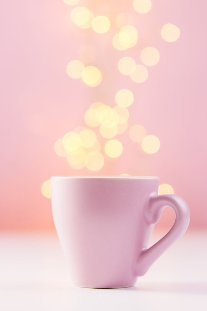 Pink coffee cup with lights bokeh