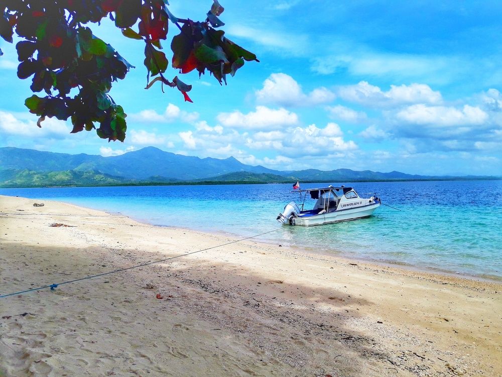 A yatch, a sand and a blue sea water