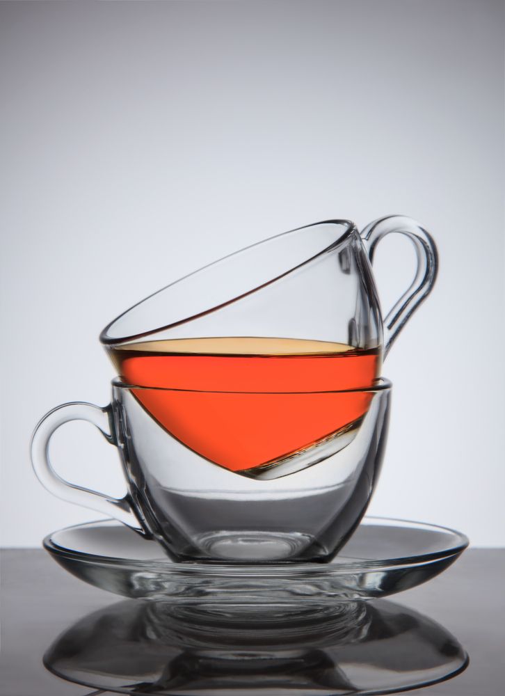 Glass cups of tea on saucer, good concept the idea, on gradient background.