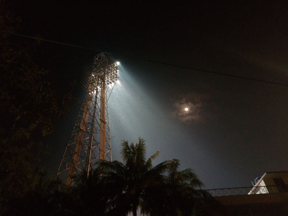 Moonlight beside floodlight.