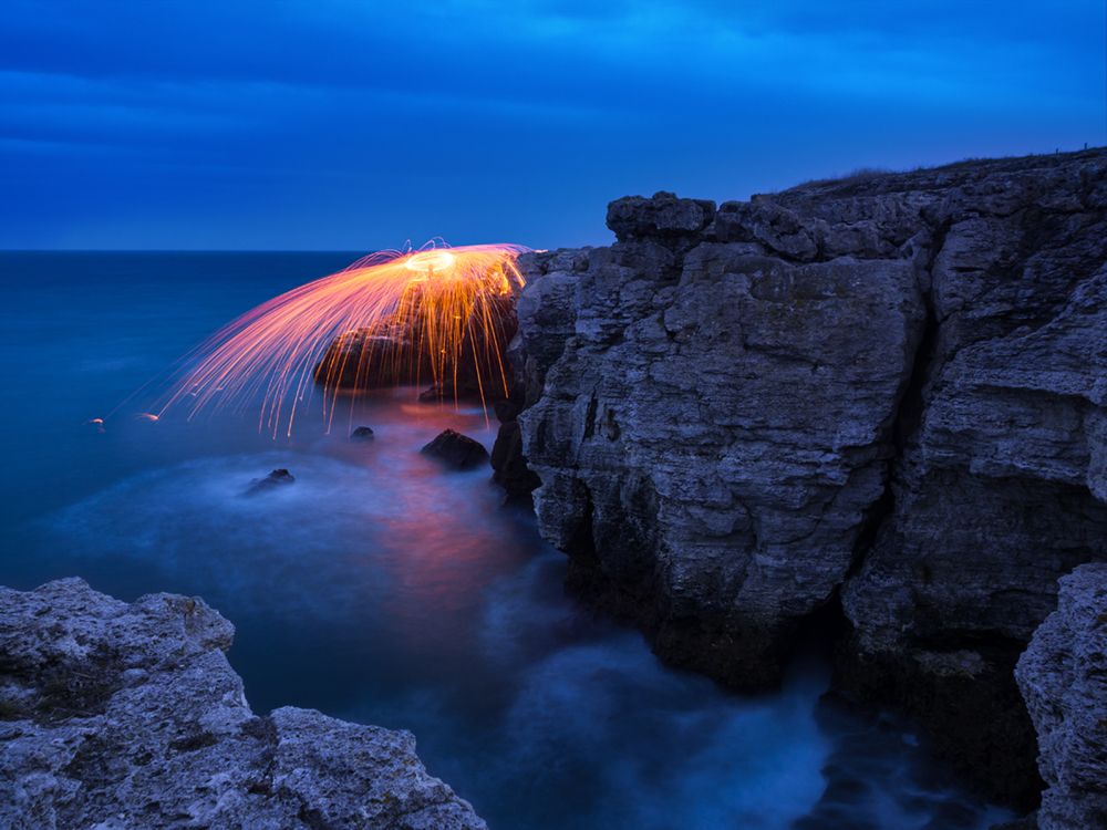 Fire splashes over rocks