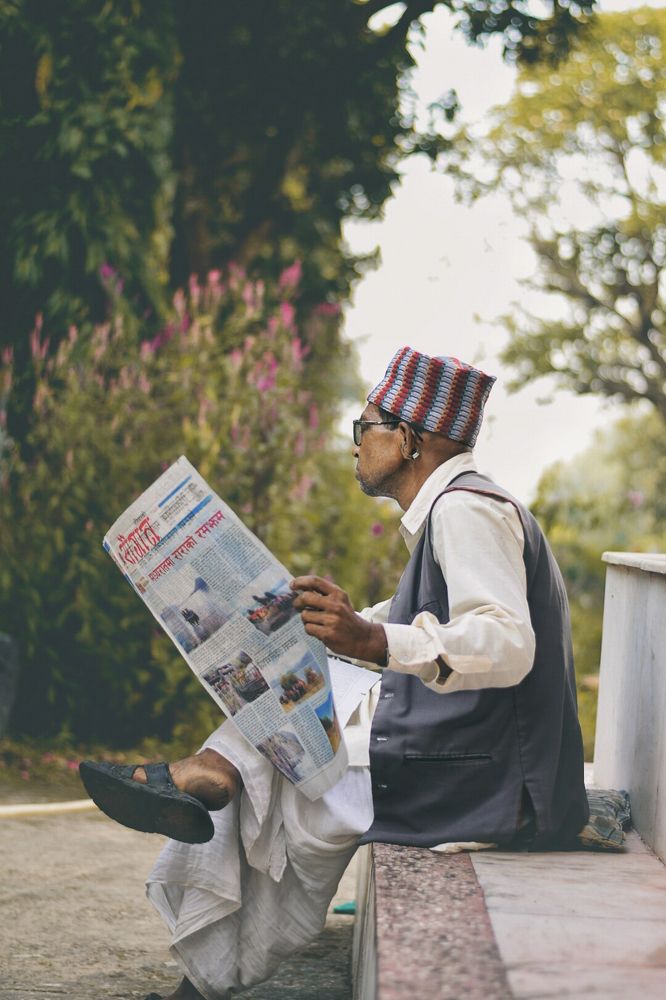 Monk reading a local newspaper