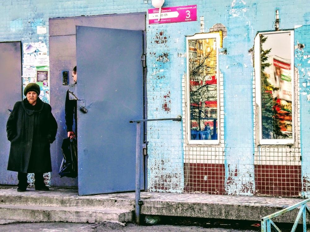 Современный русский город.Зеркальные окна,задрипанный подъезд и квадратная женщина.