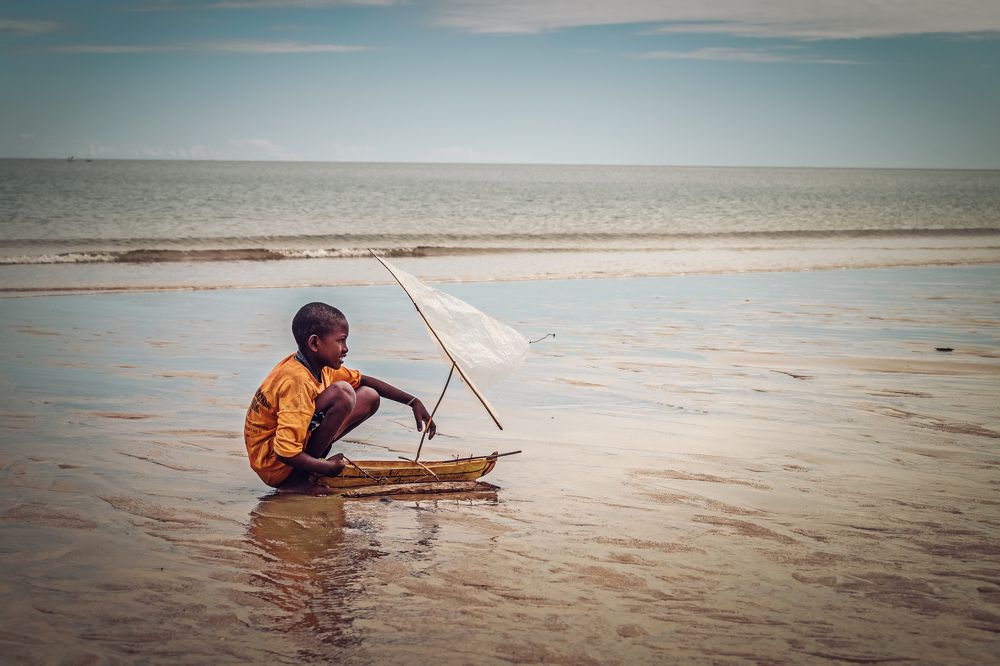 Child Playing with handmade Boat
