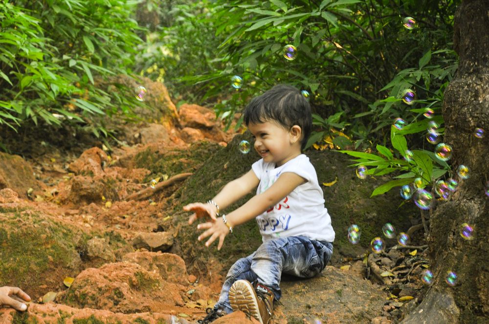 A Boy enjoying Bubbles in Nature.