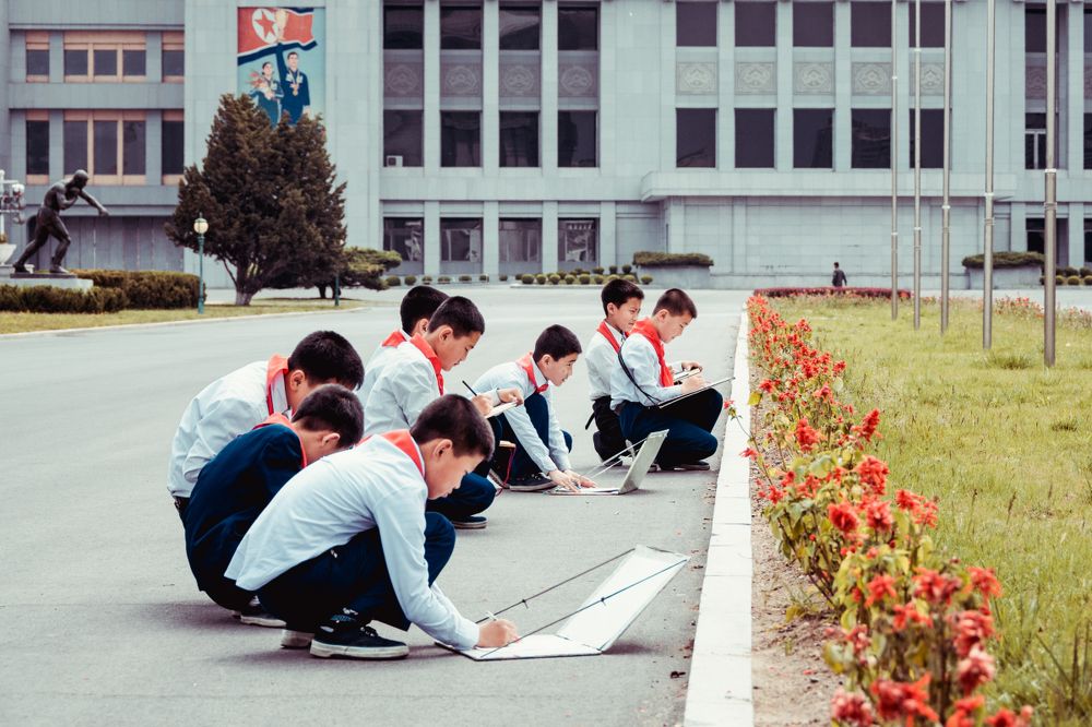 Pioneers draw on the street in Pyongyang (North Korea)