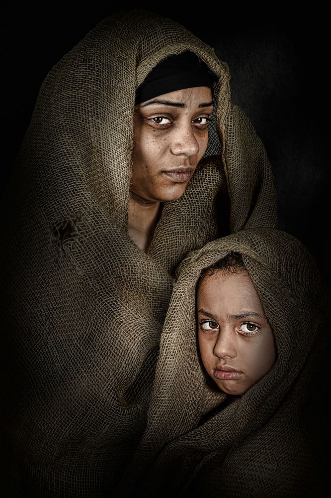 The mother's look is full of sadness and the girl's face is full of challenge