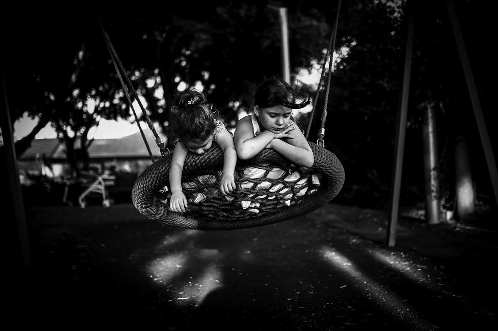 Two girls on the children`s swing.