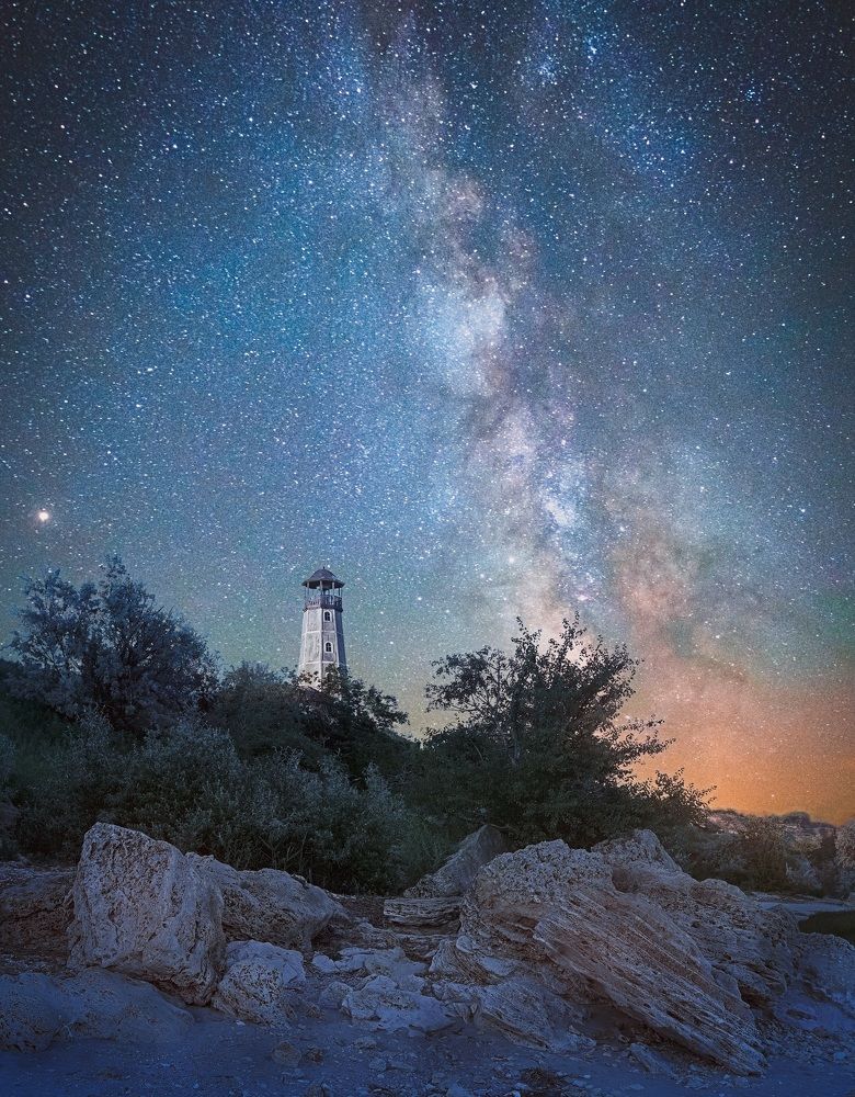 Milky Way above the lighthouse on the sea coast